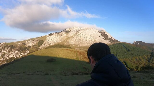 Tracking to a young boy who walks in the mountains