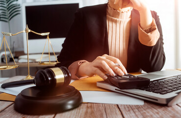 Justice and law concept.Male judge in a courtroom with the gavel, working with, computer and...
