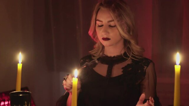 Female fortune teller lights magic incense for paranormal ritual