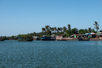 Fototapeta premium Several traditional wooden boats and houses on the shore of Chaung Thar, Myanmar
