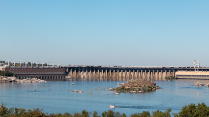 Fototapeta na wymiar Dneproges on sunny clear day. Hydro electric power plant on Dnieper river in Zaporozhye, Ukraine. View from Khortytsia island
