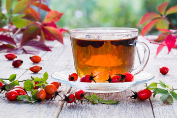 Cup of rose hip tea on a wooden table