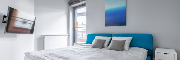 Bedroom with blue bed, panorama