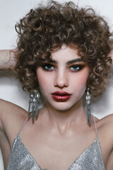 Young beautiful woman with curly hair and smoky eye makeup