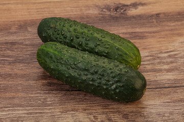 Green fresh cucumbers over background
