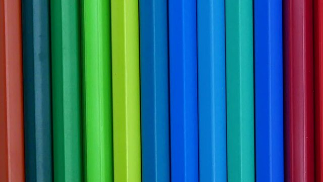 Many colors of crayons placed vertically in slow motion video