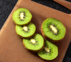 Kiwi slices on the Board on a black background.