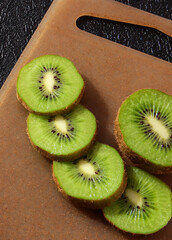 Kiwi slices on the Board on a black background.