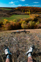 Aerial view of outdoor cycling. Mountain bike in wild nature landscape background. Panoramic landscape of central Russia agricultural countryside with hills.