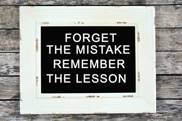 Text Forget the mistake remember the lesson written on chalkboard