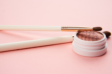 makeup brushes and eyeshadow professional cosmetics on pink background