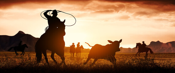 Fototapeta na wymiar Silhouette of a cowboy riding a horse roping a calf.