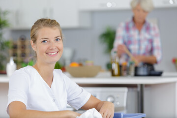 happy woman sitting with financial papers in kitchen and smiling