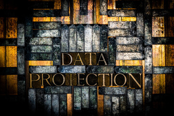 Photo of real authentic typeset letters forming Data Protection text on vintage textured grunge copper and gold background
