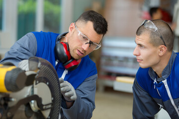 apprentice and man working in a factory