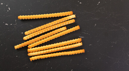 Grissini, also known as breadsticks on black marble like table, view from above