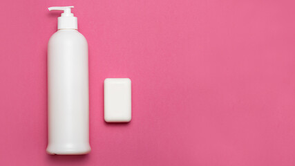 Shampoo and soap on pink background with copy space