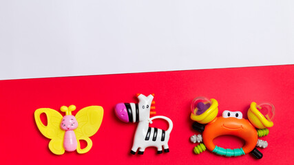 colorful set of baby rattles. beanbag butterfly,zebra,.crab on orange and white background with copy space/
