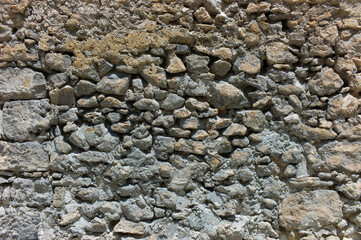 Old wall constructed from different types and sizes of stones and rocks
