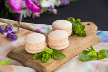 Fototapeta na wymiar Macarons and mint for dessert - healthy organic summer dessert. Creative atmospheric decoratio