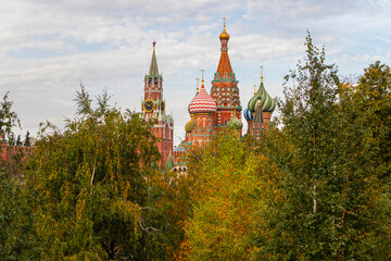 Fototapeta na wymiar Spasskaya Tower and the Church of Vasily the Blessed through the trees of Zaryadye Park