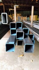 Ends of square and rectangular steel sticks with blue ends.