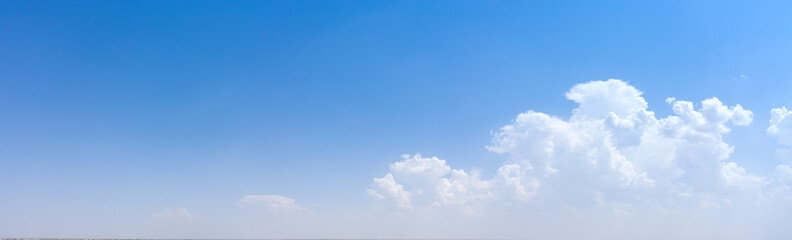 Naklejka na ściany i meble White clouds on a background of blue sky. Panorama