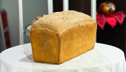 Loaf of black bread on a white linen tablecloth
