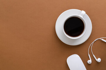 Flat lay with coffee cup on brown background. Copy space.
