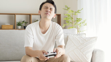 リビングでテレビゲームをする男性