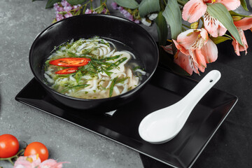 Bowl of chicken noodle on gray concrete background