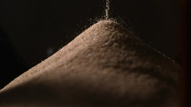 Detail of sand in bottom of hourglass, falling sand, sand collapsing