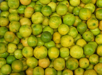 green and yellow oranges for sale in the market