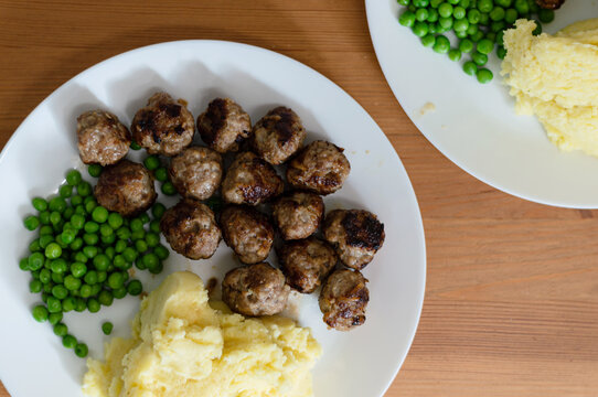 top down view of Swedish meatballs on white plates on wooden table