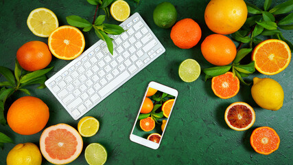Health food theme background workspace with citrus fruit on dark green textured background. Top view blog hero header creative composition flat lay with negative copy space.