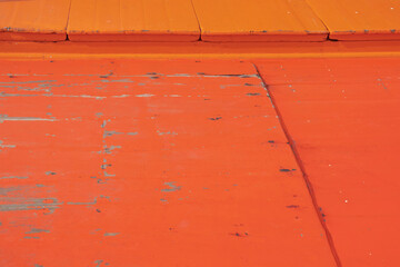 Wooden floor on a fishing boat painted in orange.