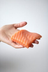 Hand holding a piece of salmon