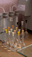 Measure volume flasks on a wooden lab table, closed with plastic corks,