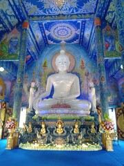 White buddha statue in blue temple at chiangrai Thailand