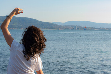 girl doing pilates exercises in front of the sea with the bay in the background
