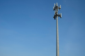 Fototapeta na wymiar Mobile phone tower against blue sky