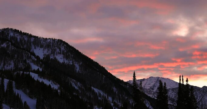 Spectacular sunset view of moving red clouds over mountains in winter from Snowbird in Little Cottonwood Canyon in the Wasatch Range near Salt Lake City, Utah, USA.