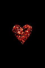 Dark romantic view of burning fire embers in the shape of a heart.