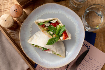 Mediterranean greek pita pocket with salad and feta cheese inside, appetizing commercial photo