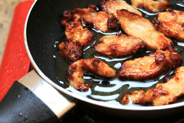 close-up Frying meat in a black pan on a gas stove