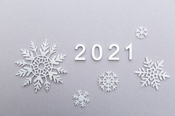2021 silver numbers festive composition with snowflakes on a grey background with copy space. New year and Christmas concept