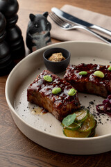 Teriyaki sauce crab cakes, glazed and spicy with edamame beans, close up on wooden background in soft light, fancy restaurant photo