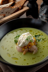 Close up of cream soup with crab meat and shrimps on wooden table in a fancy fish restaurant, soft light, appetizing food commercial