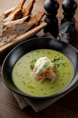 Cream soup with crab meat and shrimps on wooden table in a fancy fish restaurant, soft light, appetizing food commercial