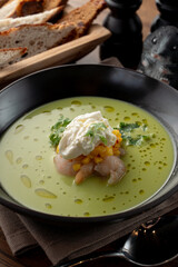 Pea and corn green cream soup with shrimps and expensive cheese in a fine dining restaurant, close up, macro texture